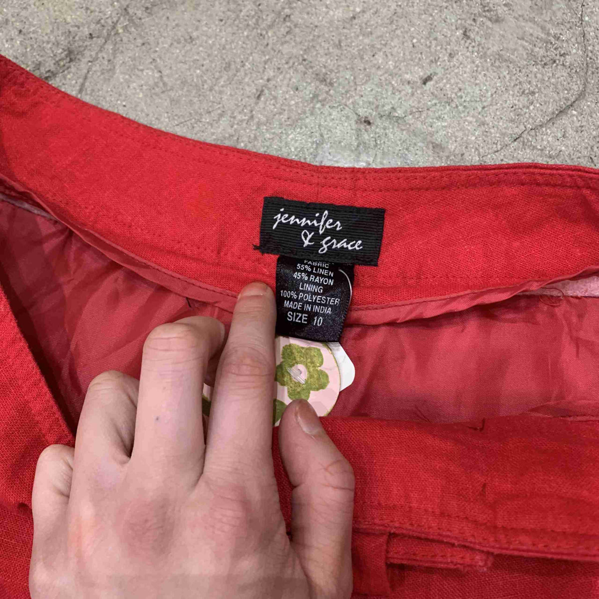 a person holding a label on a red dress.