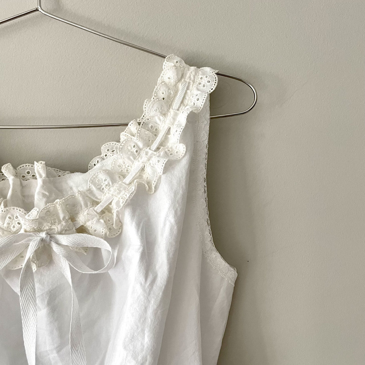 a white blouse hanging on a hanger.