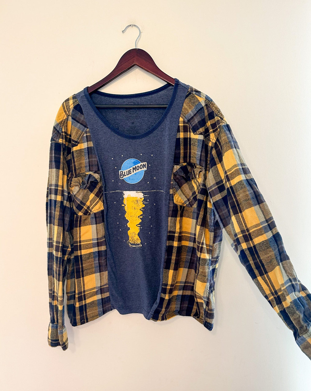 a blue and yellow t - shirt hanging on a wall.