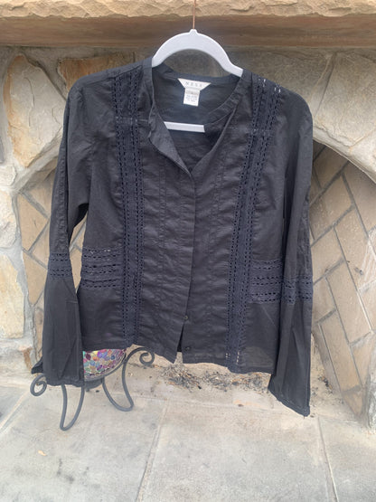 a black jacket hanging on a stone wall.