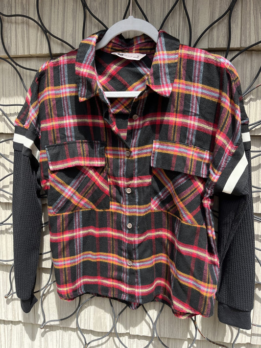 A black and red plaid shirt hanging on a wall.