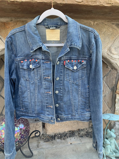 A Greta Van Fleet Denim Jacket hanging on a clothes rack.