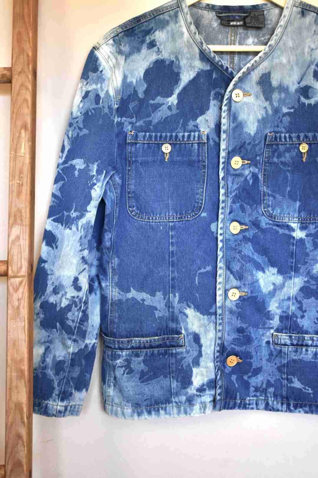 a blue jean jacket hanging on a wall.