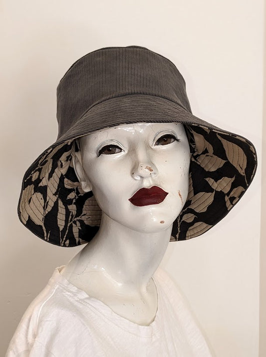 A mannequin wearing a hat with leaves on it.