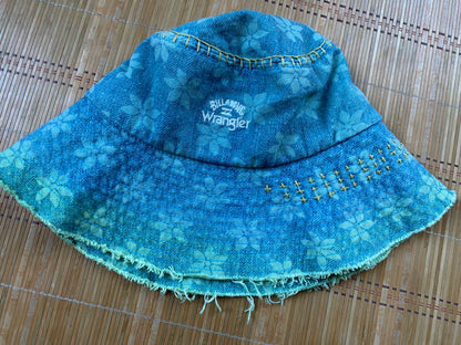A blue denim bucket hat on a bamboo mat.