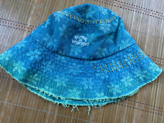 A blue denim bucket hat on a bamboo mat.