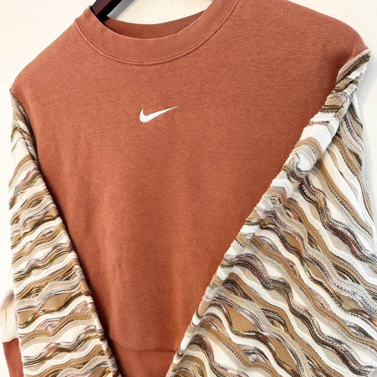 A nike sweatshirt hanging on a hanger.