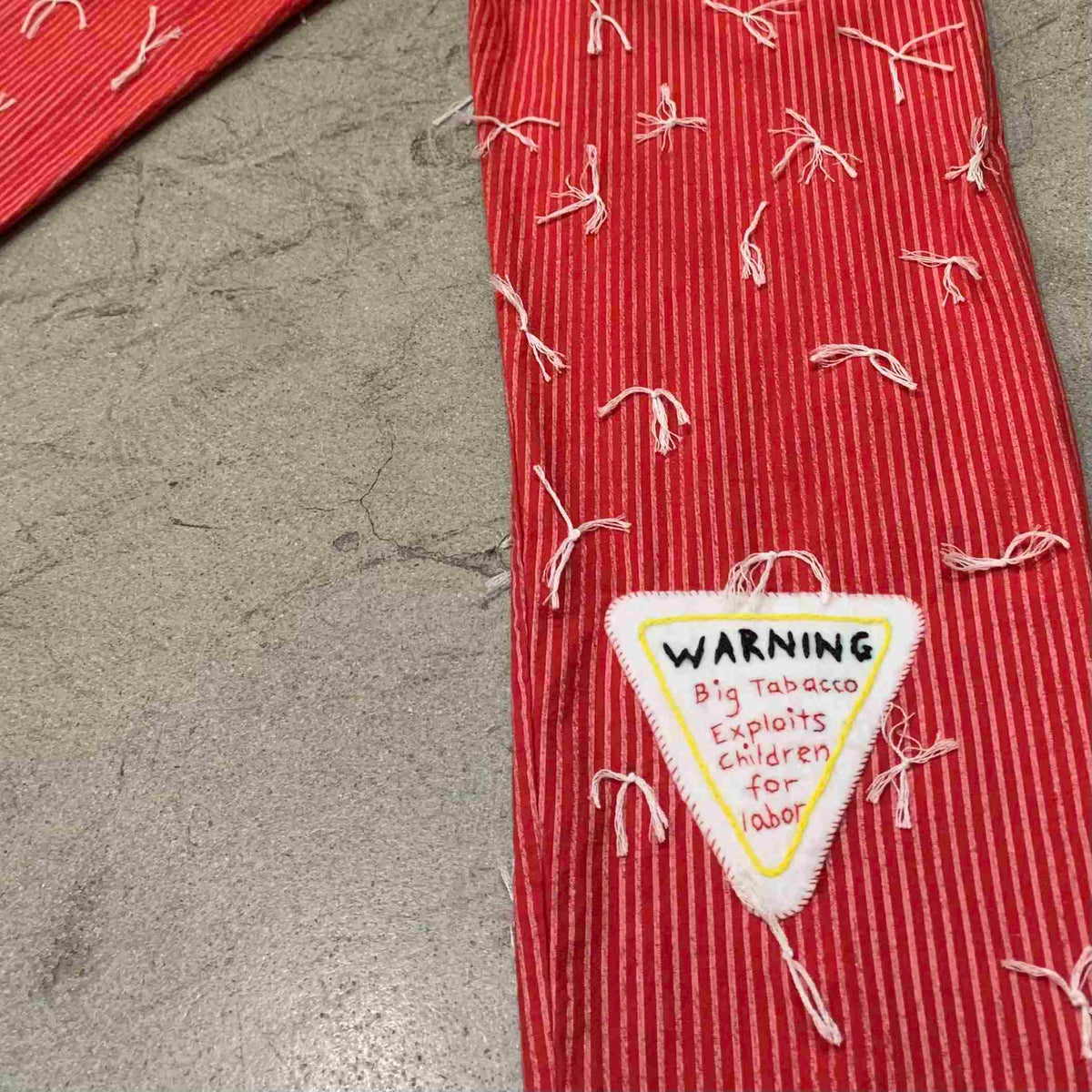 a red tie with a warning sign on it.