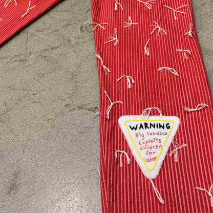 a red tie with a warning sign on it.