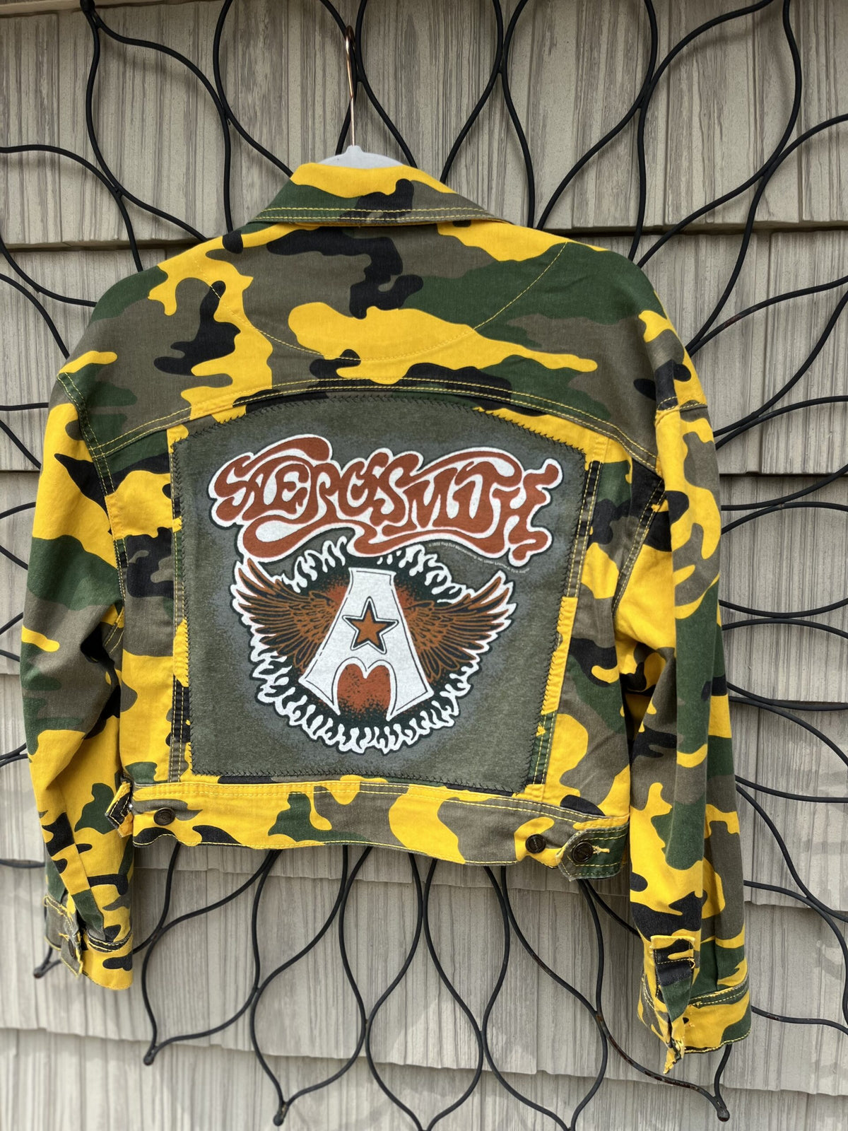 a camouflage jacket hanging on a wall.