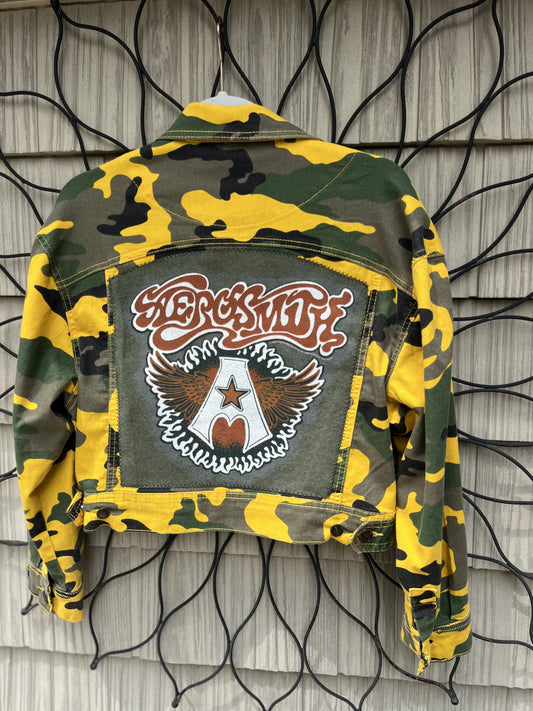 a camouflage jacket hanging on a wall.