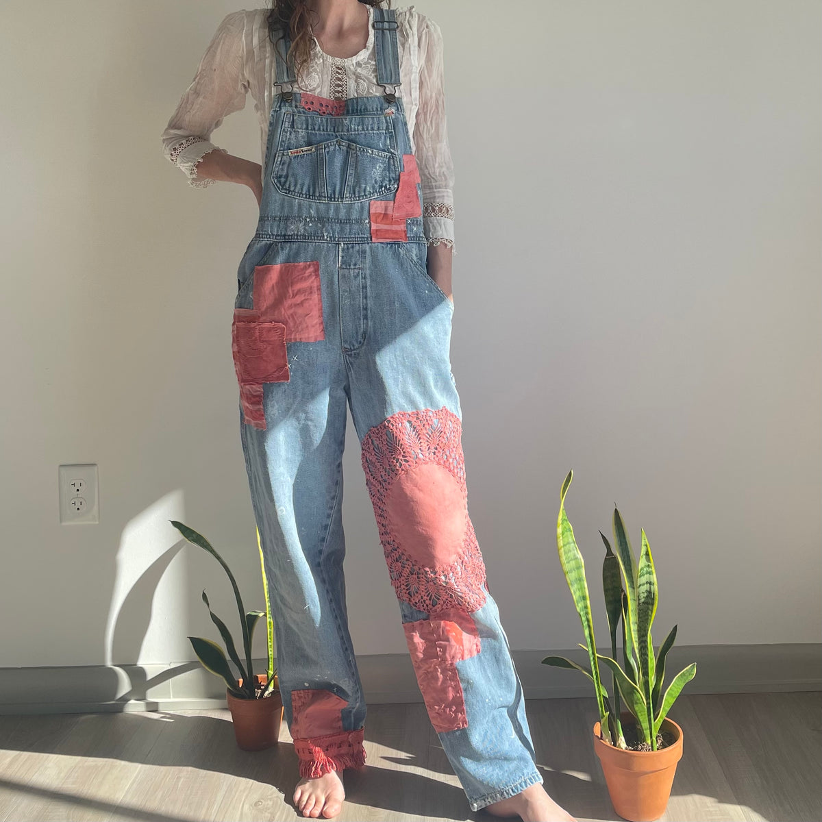 A woman standing in front of a plant.