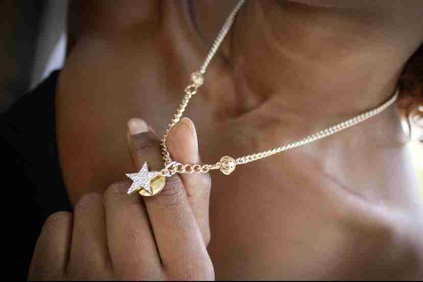 a woman holding a star necklace in her hand.