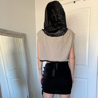 A woman wearing a black hoodie and black skirt.