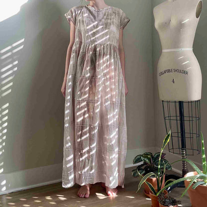 a woman standing next to a dress on a mannequin.