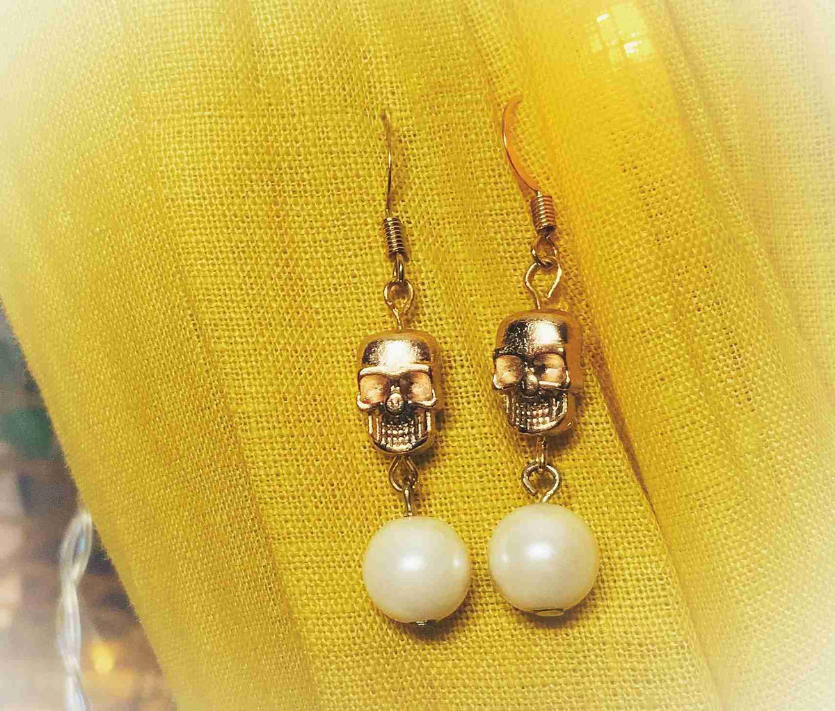 a pair of earrings with a skull on them.