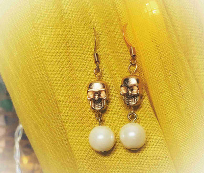 a pair of earrings with a skull on them.