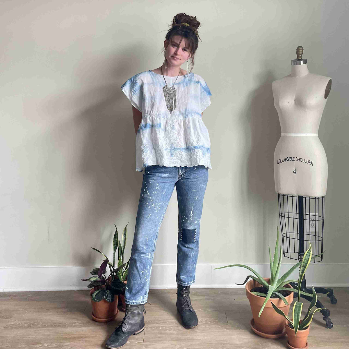 a woman standing in front of a mannequin.