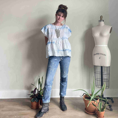 a woman standing in front of a mannequin.