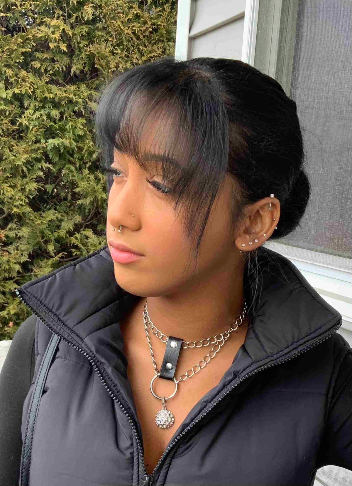 a woman with black hair wearing a black jacket.