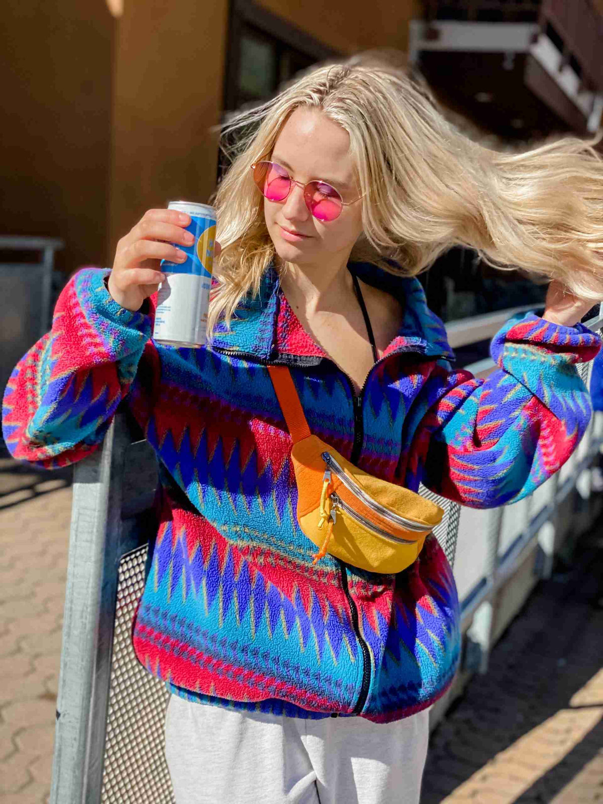 a woman with sunglasses and a colorful jacket.
