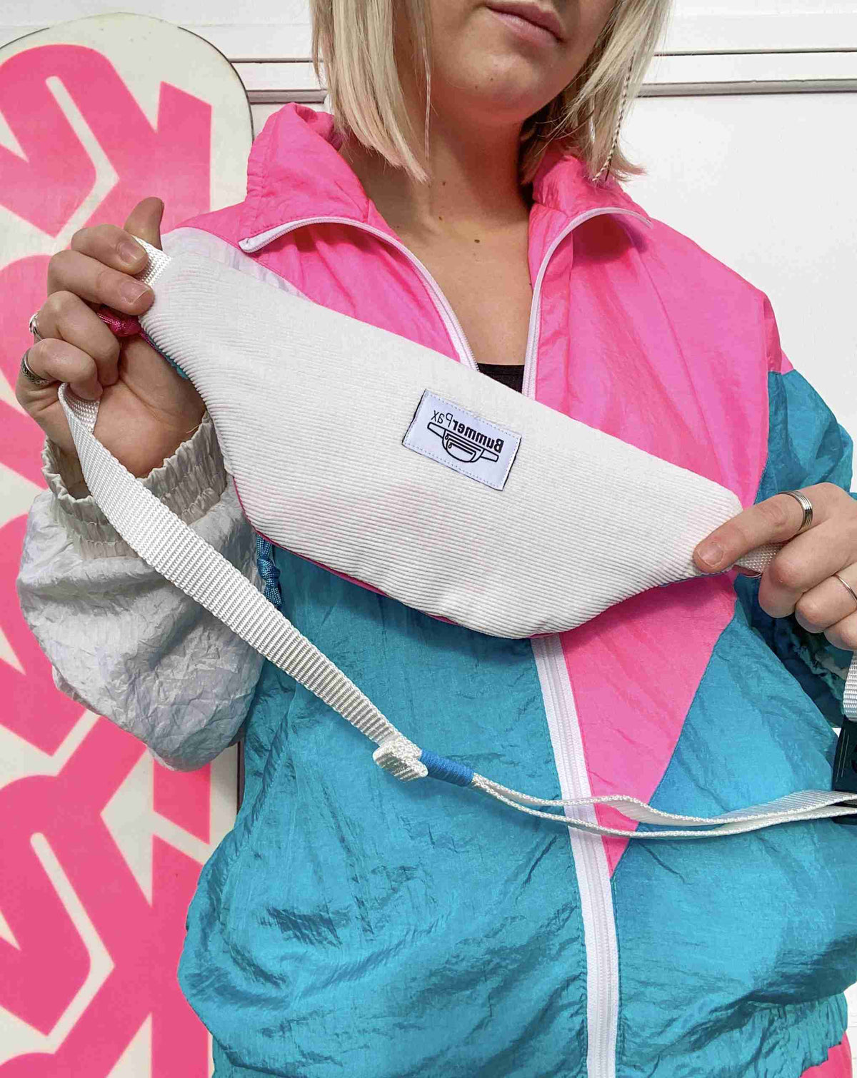 a woman in a pink and blue jacket holding a broken arm.