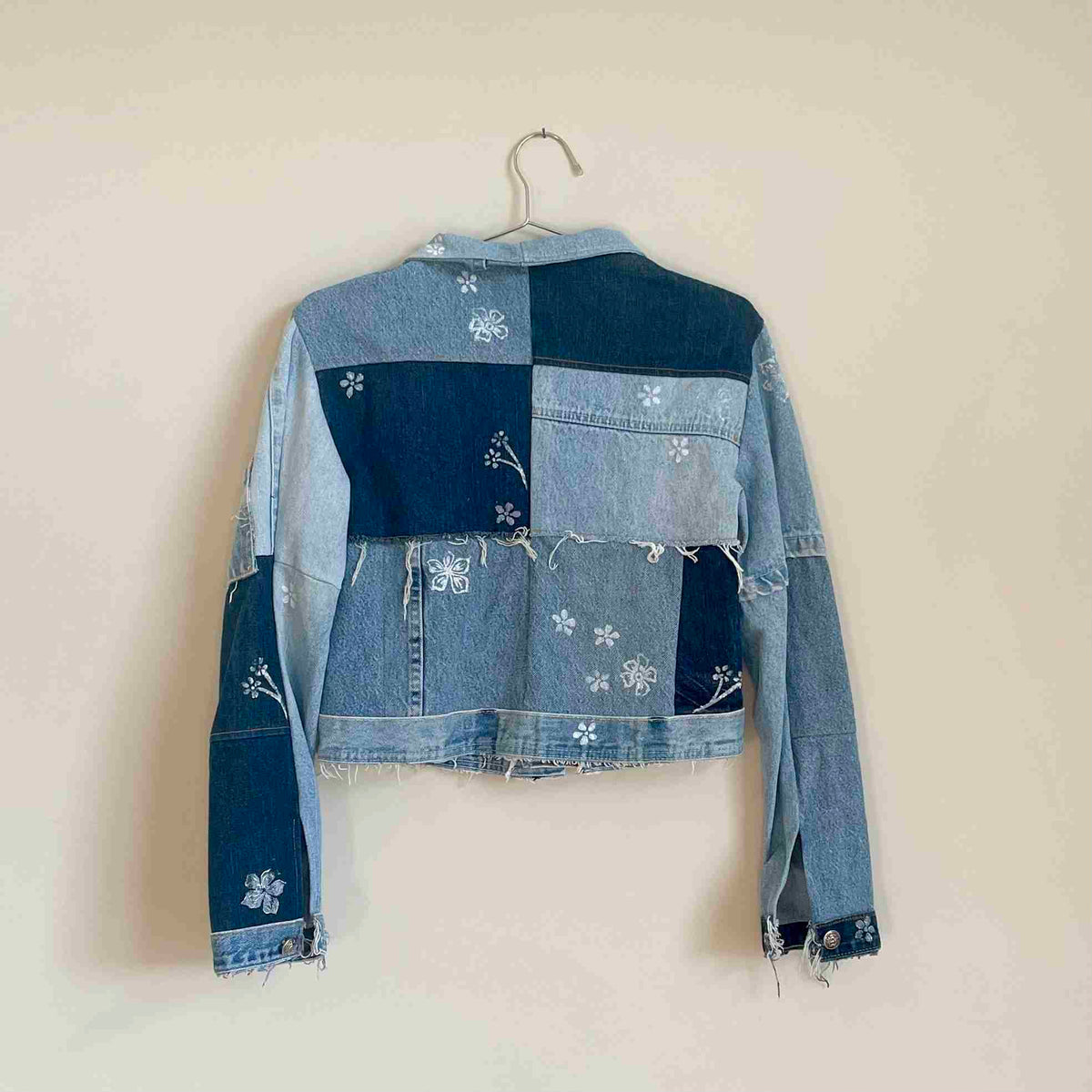 a jean jacket hanging on a wall.