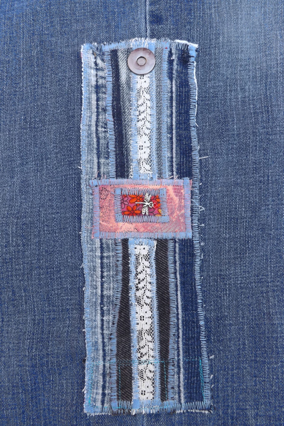 An upcycled denim cuff bracelet with dragonfly charm.