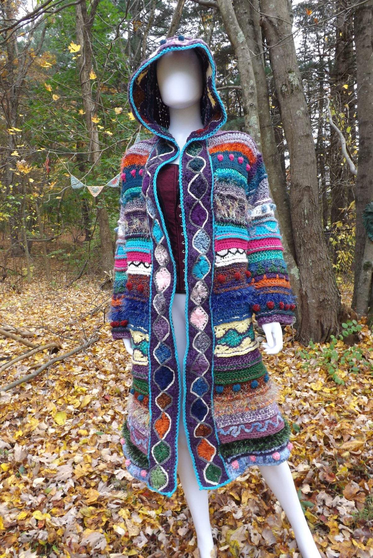 A long crochet coat with elf hood and medallion border and lots of textures.