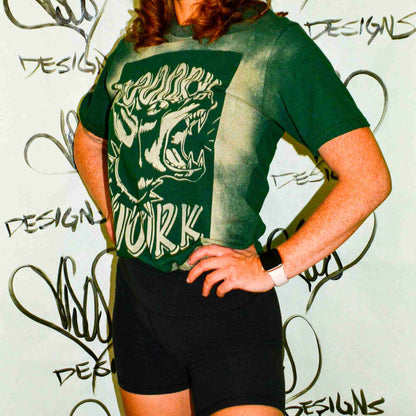a woman wearing a green shirt and black shorts.