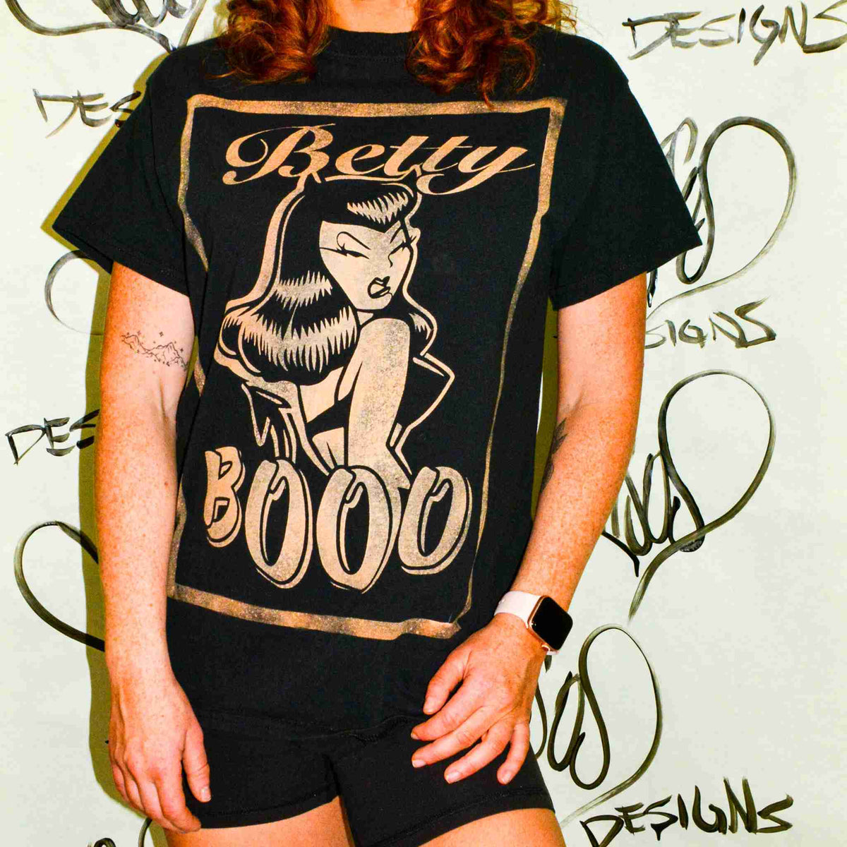 a woman with red hair wearing a black betty boo t - shirt.