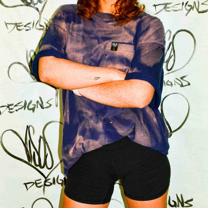 a woman with her arms crossed standing in front of a wall.