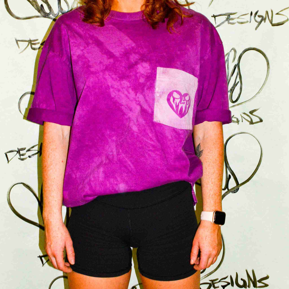 a woman wearing a purple shirt and black shorts.