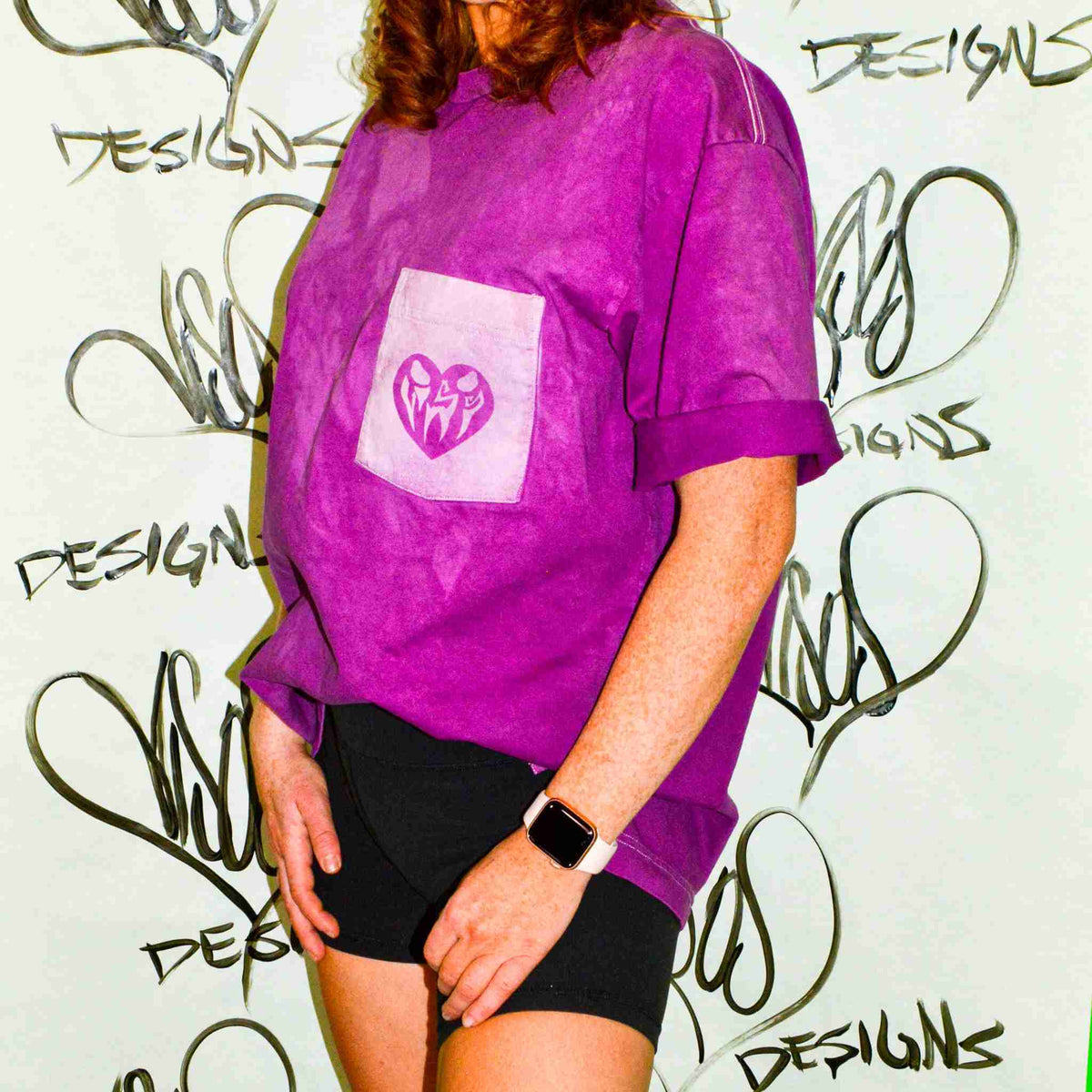 a woman wearing a purple shirt and black shorts.