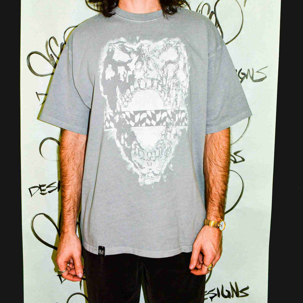 a man standing in front of a wall with graffiti on it.