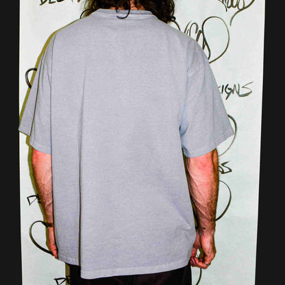 a man with long hair wearing a gray shirt.