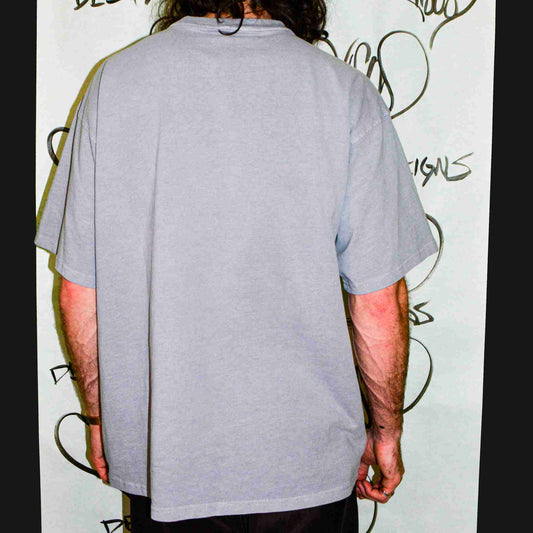 a man with long hair wearing a gray shirt.