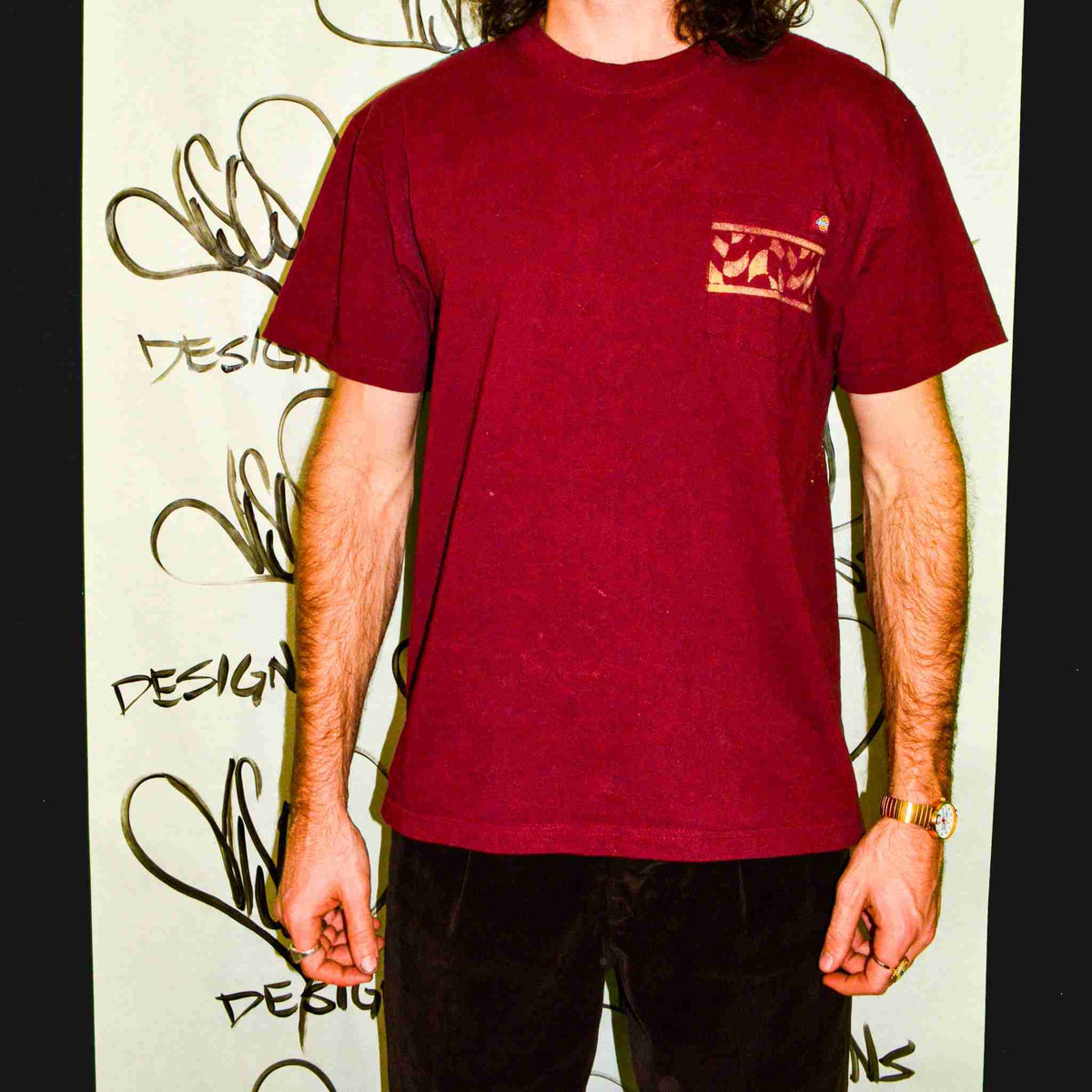 a man with long hair wearing a red shirt.