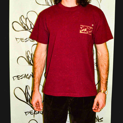 a man with long hair wearing a red shirt.