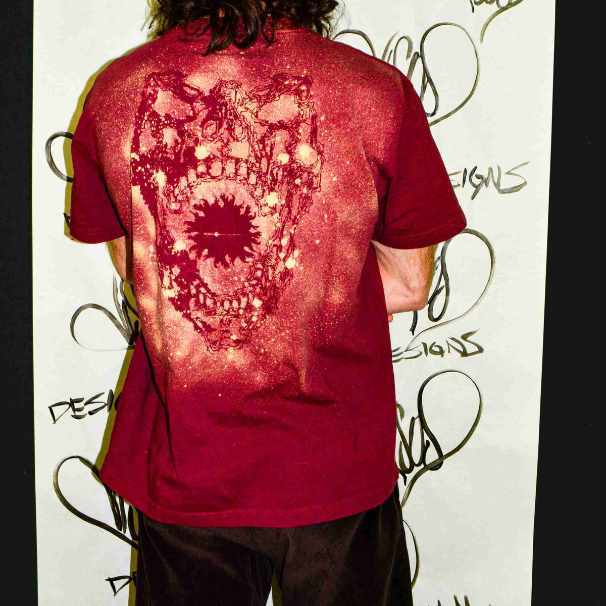 a man with long hair wearing a red shirt.