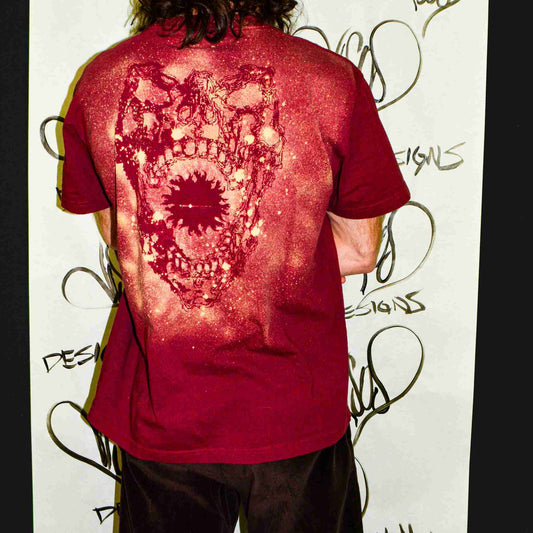 a man with long hair wearing a red shirt.