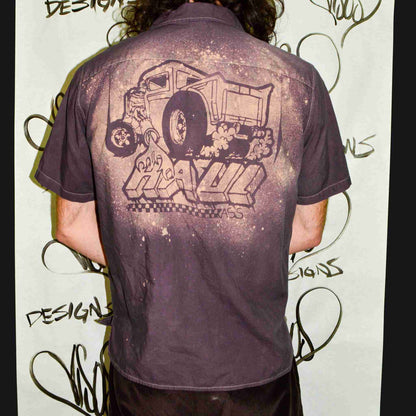 a man with long hair wearing a purple shirt.