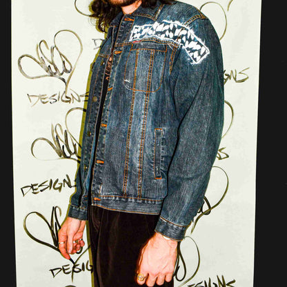 a man with long hair wearing a jean jacket.