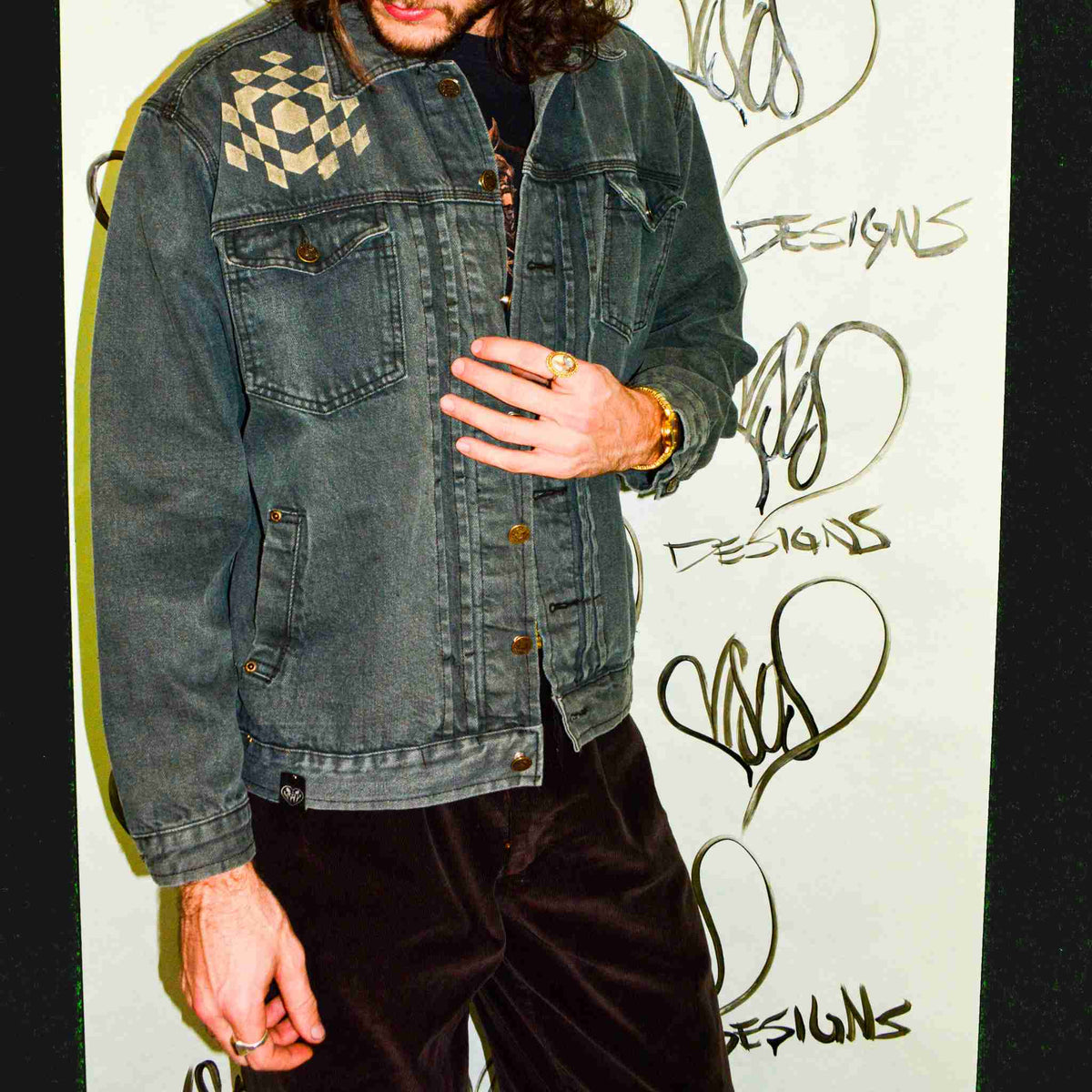 a man with long hair and a denim jacket.