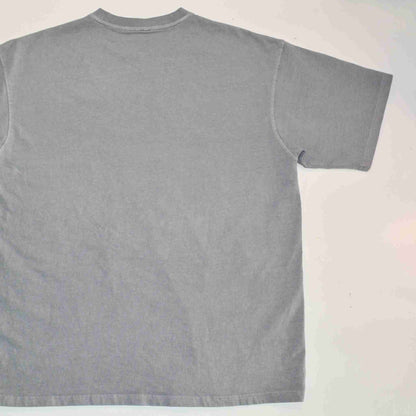 a gray t - shirt is laying on a white surface.