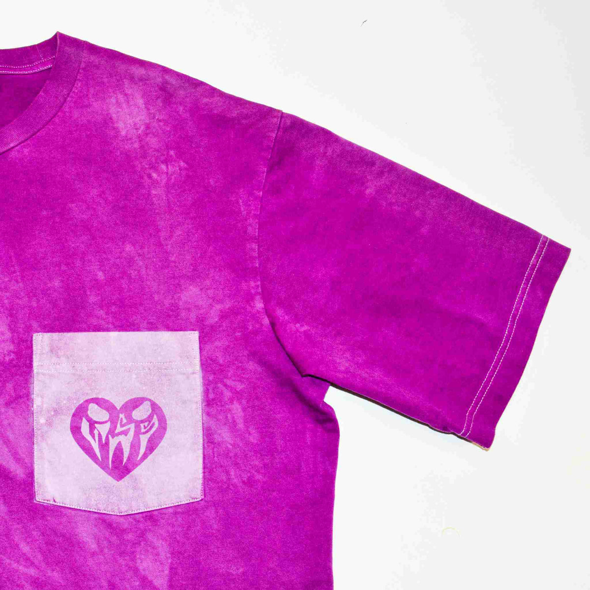 a purple shirt with a heart and two initials on it.