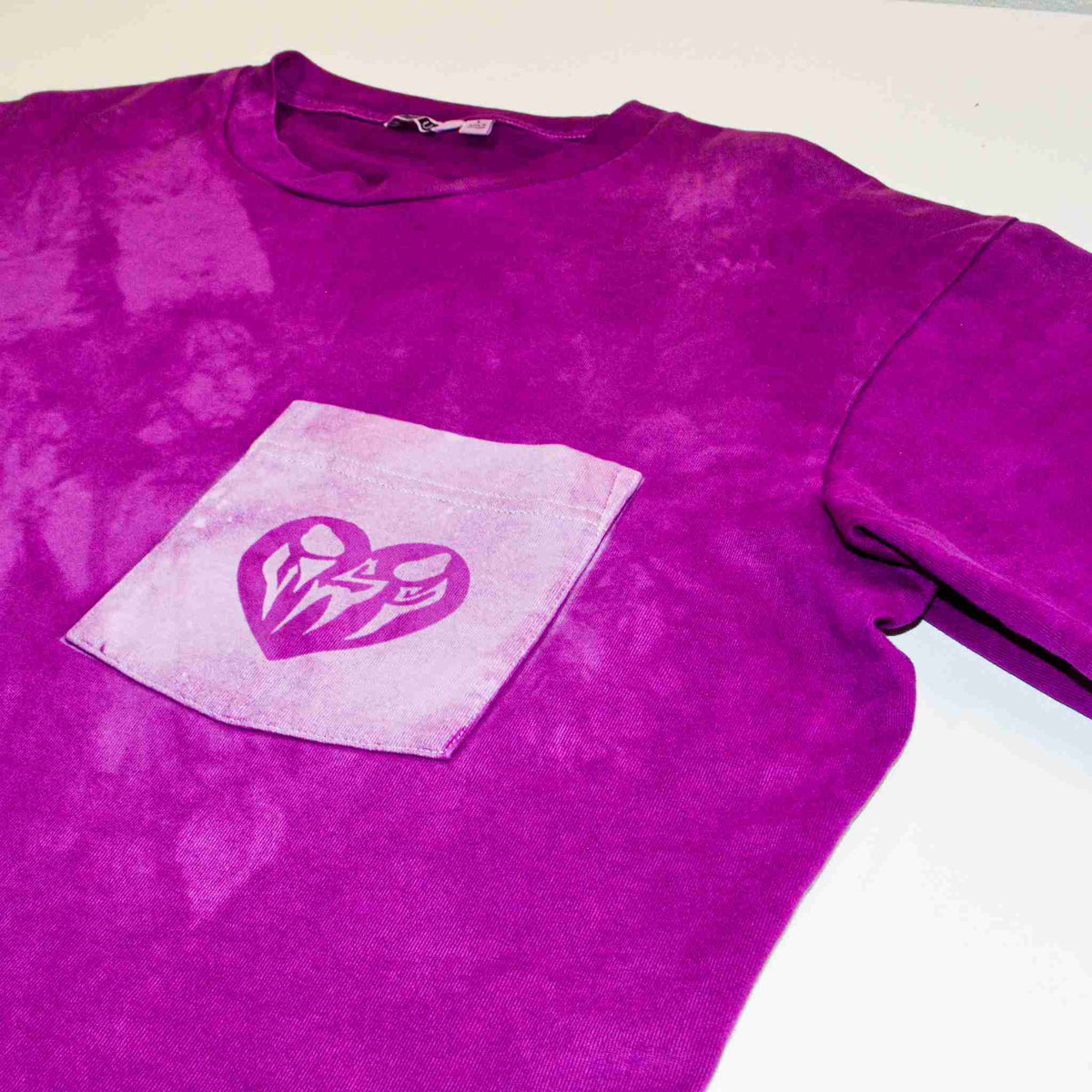 a purple t - shirt with a heart on it.