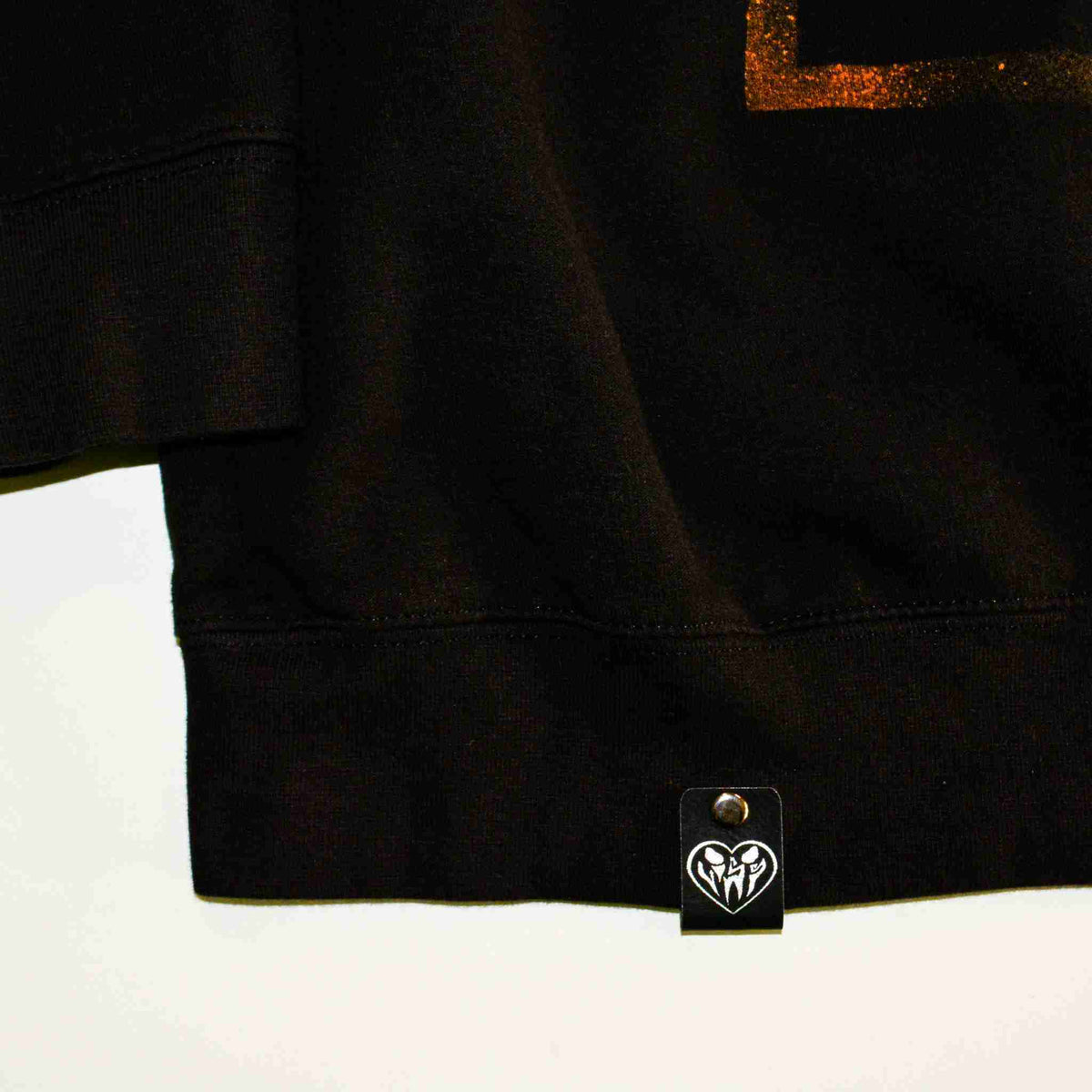 a black t - shirt with a gold heart on it.