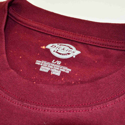 a close up of a red shirt with a logo on it.