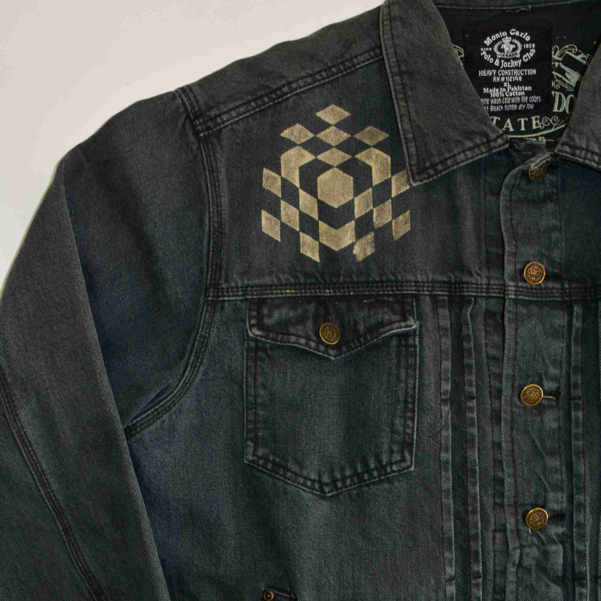 a black jean jacket with a checkered design on it.